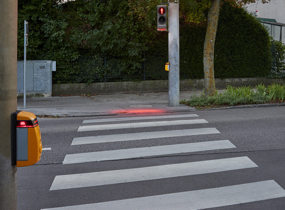 Swarco’s SafeLight shines a red light down to the pavement next to the traffic light pole