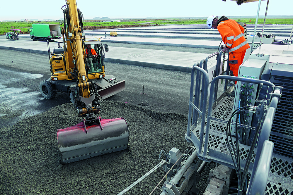 Concrete was placed in front of the SP 62i slipform paver by an excavator and then distributed with the spreader plow