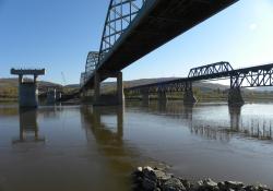 From the eastern bank of the Peace River, the new piers await arrival of the deck