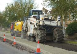 Spreading material to strengthen the tar bound road