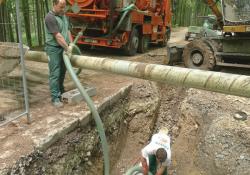 men laying pipe under rural road