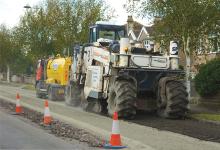 Spreading material to strengthen the tar bound road