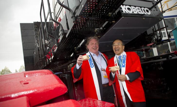 Herman Smit (Left) takes delivery of a new crane from Kobelco president and CEO Isao Aida